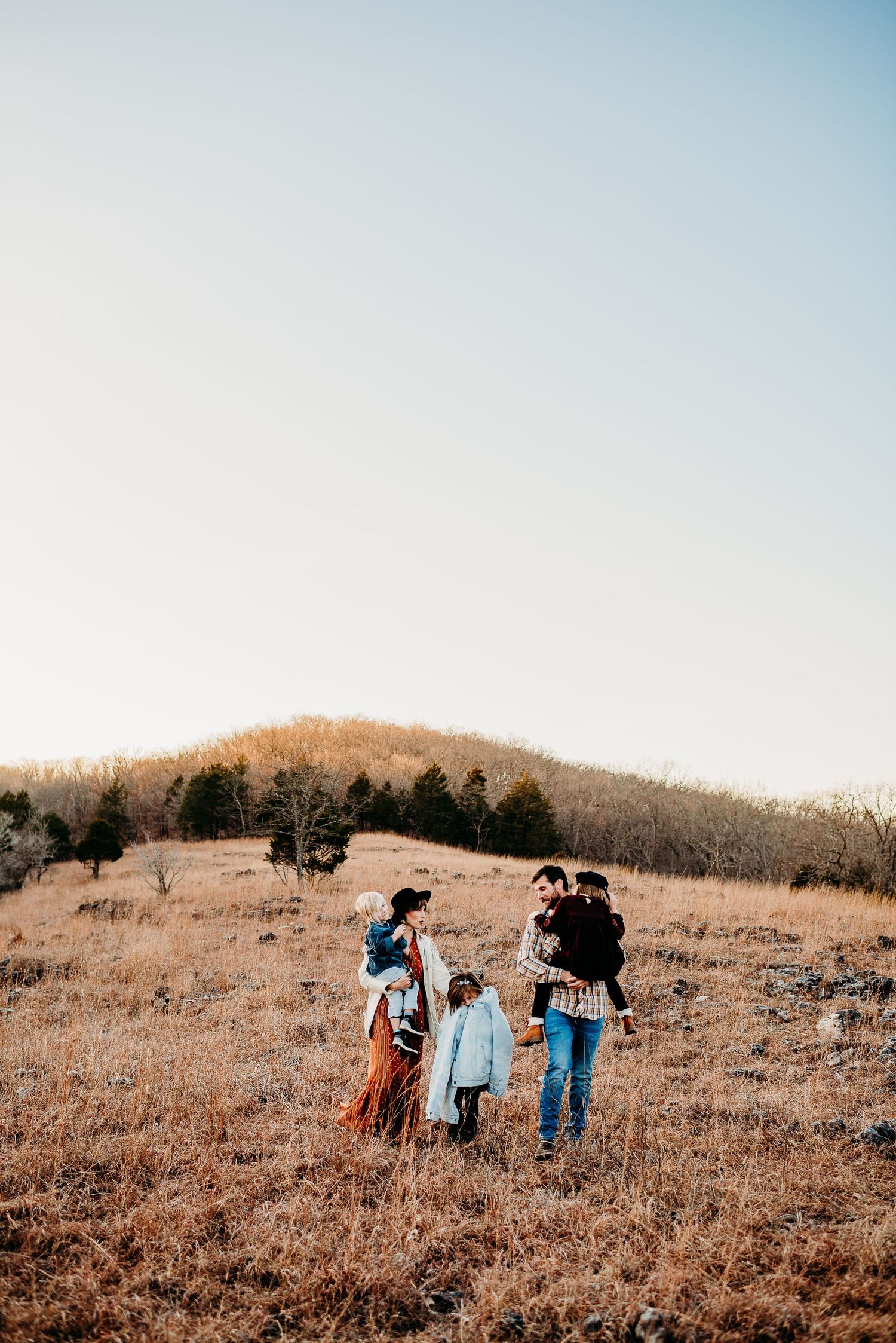 A scenic fall hillside view shows a family walking together in the distance.