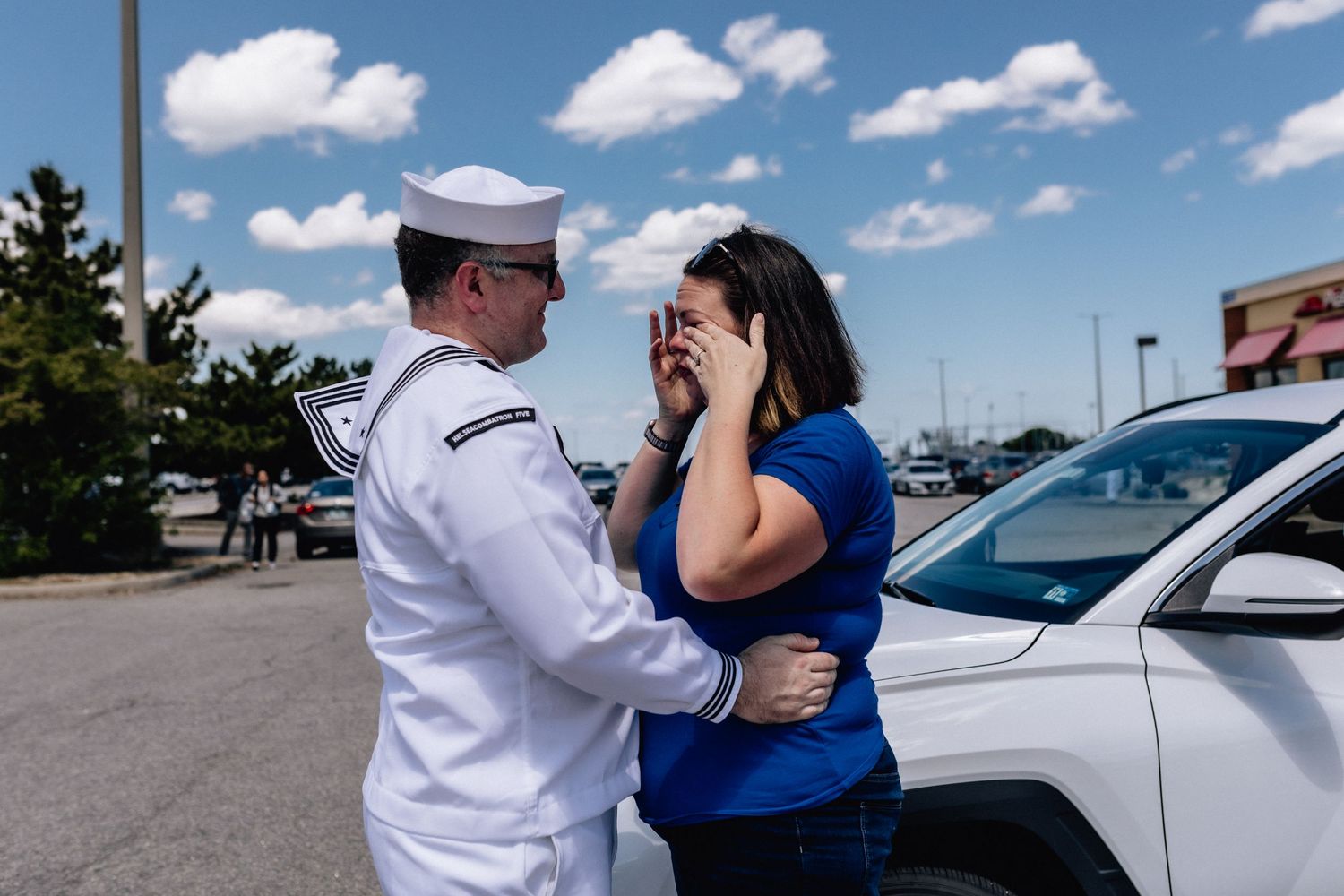 norfolk, virginia military homecoming in the ship parking lot with a woman crying and man embracing her
