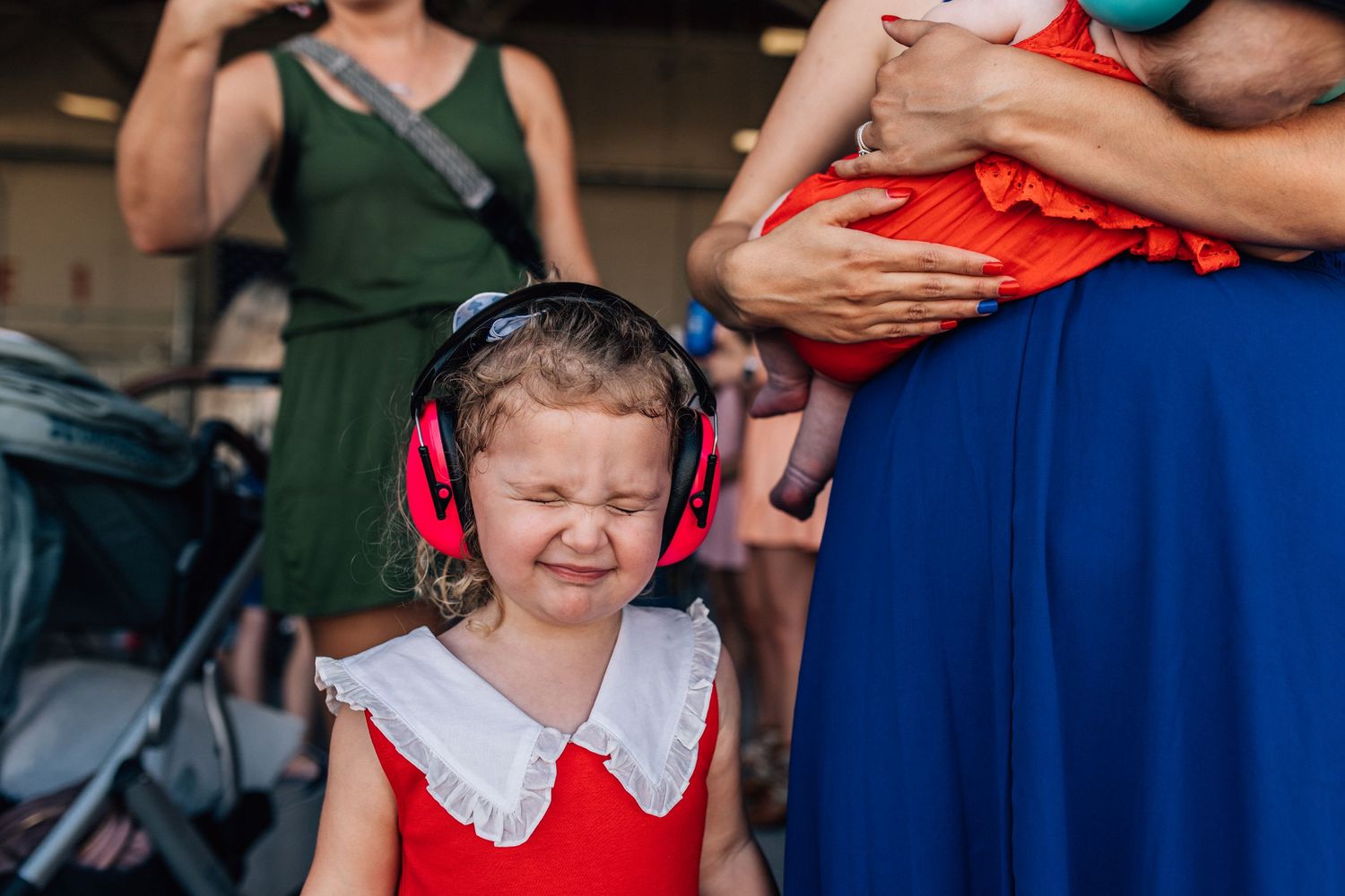little girl with hearing protection on waiting to be reunited with military father in norfolk, virginia