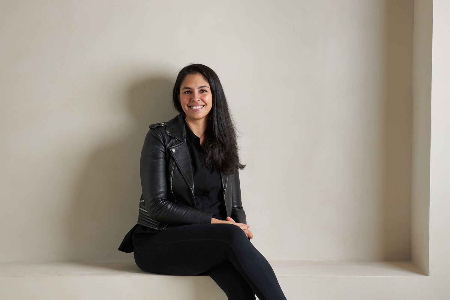 Studio photoshoot featuring casual poses against a minimalist white wall backdrop.