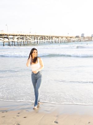 Girl portrait walking on the beach with the San Clemente pier in the background