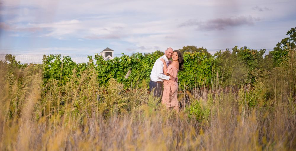 Couple embracing among the flowers and greenery of a park in Long Island engagement session