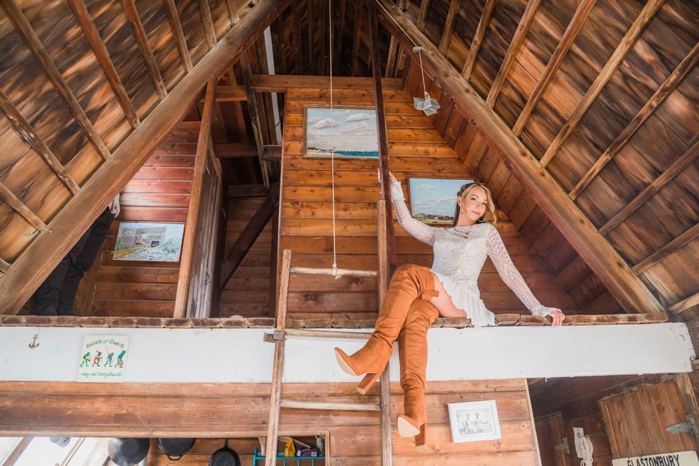 Bride seated, posing for her photo inside a barn on Long Island