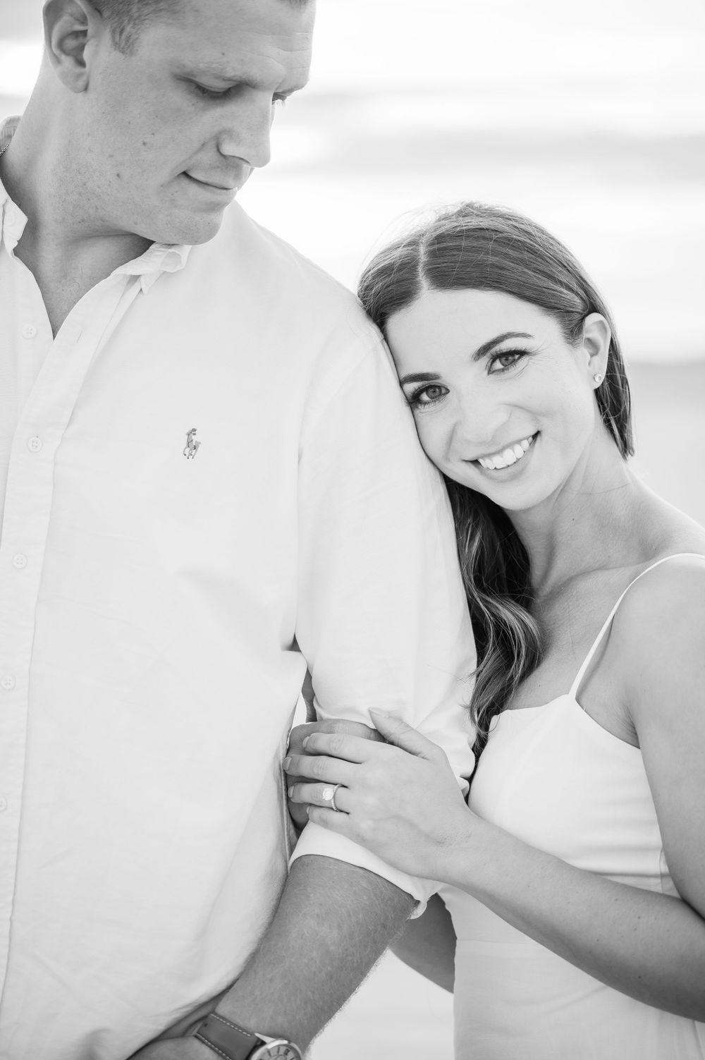 Woman leaning on her partner's arm as he looks at her with admiration.