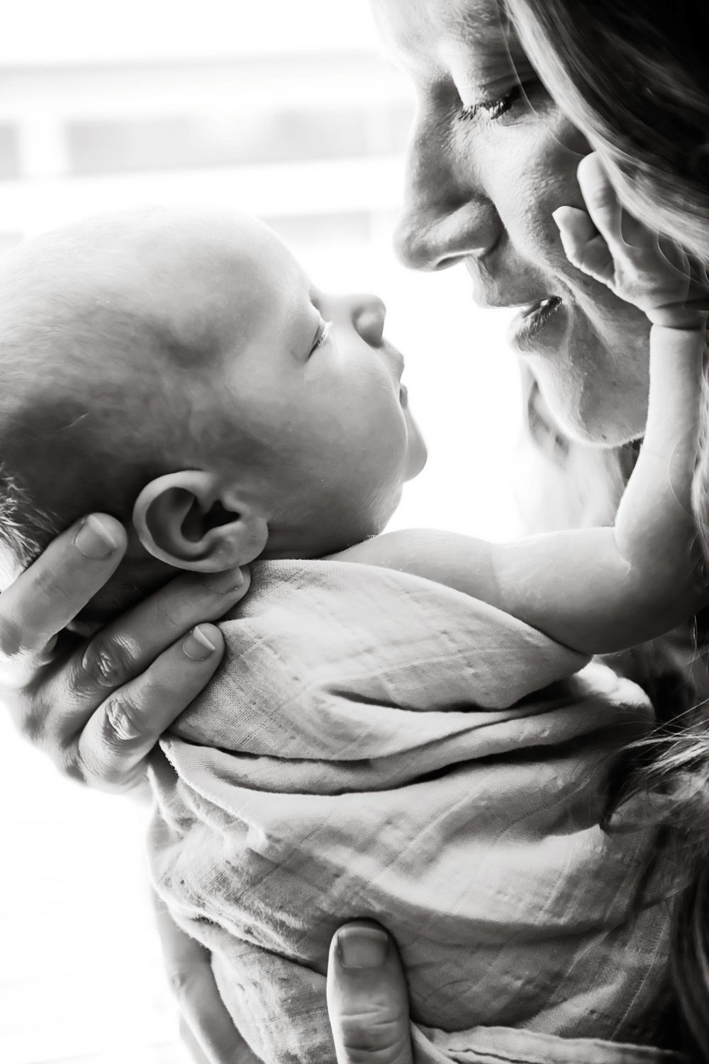 Intimate black and white close-up photo sequence showing gentle parent-baby bonding moments.