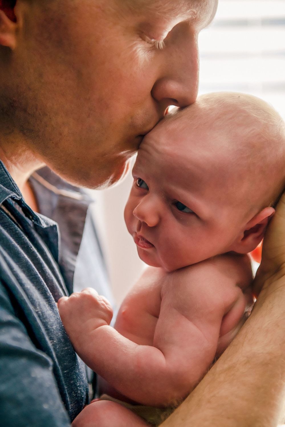 Close-up series captures tender moments between parent and infant in natural light.