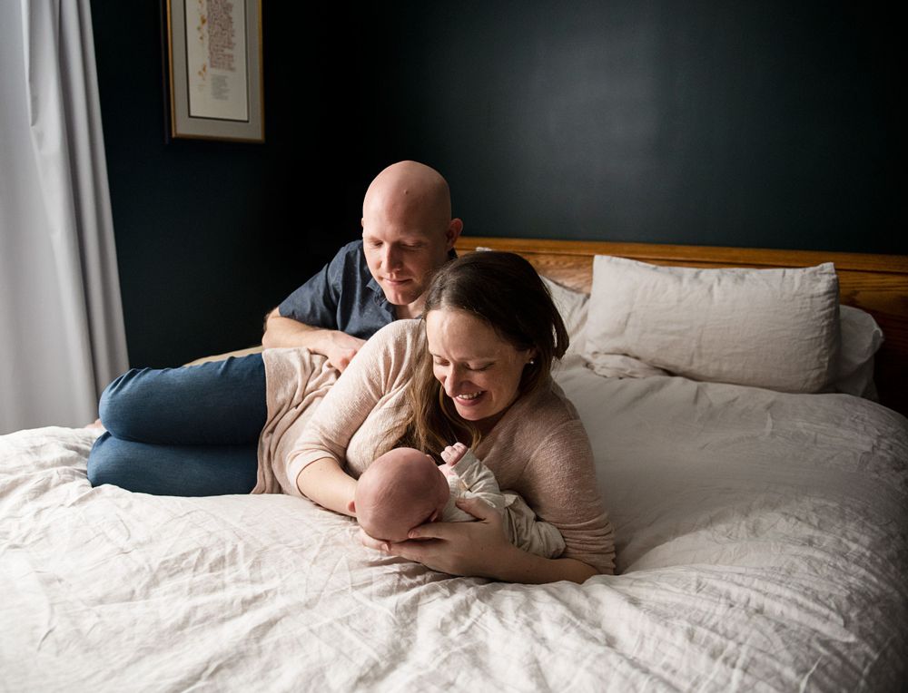 Sweet lifestyle photos showing nurturing moments between family members on a comfortable bed.
