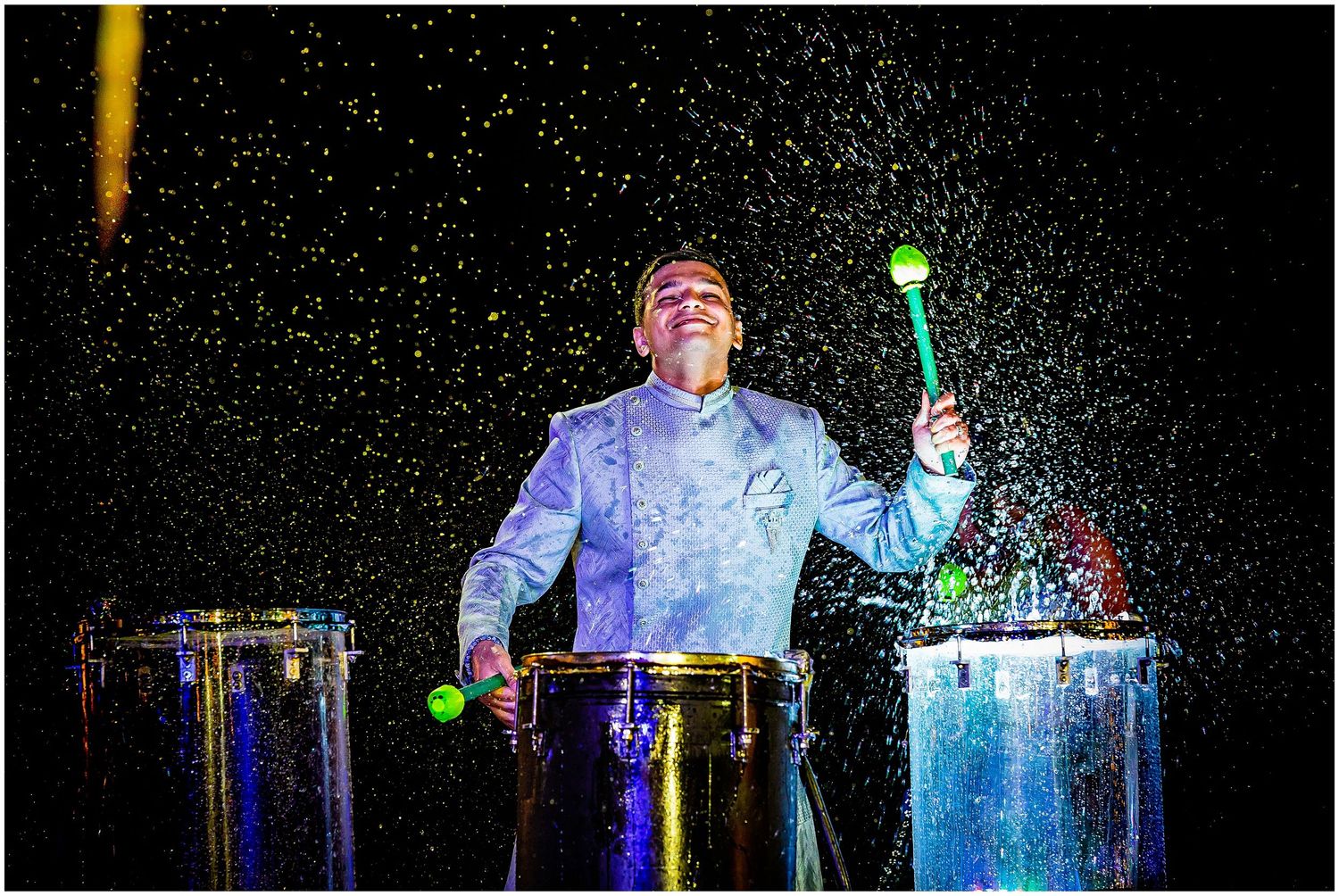 Performer creates magical light effects with illuminated drums at night.
