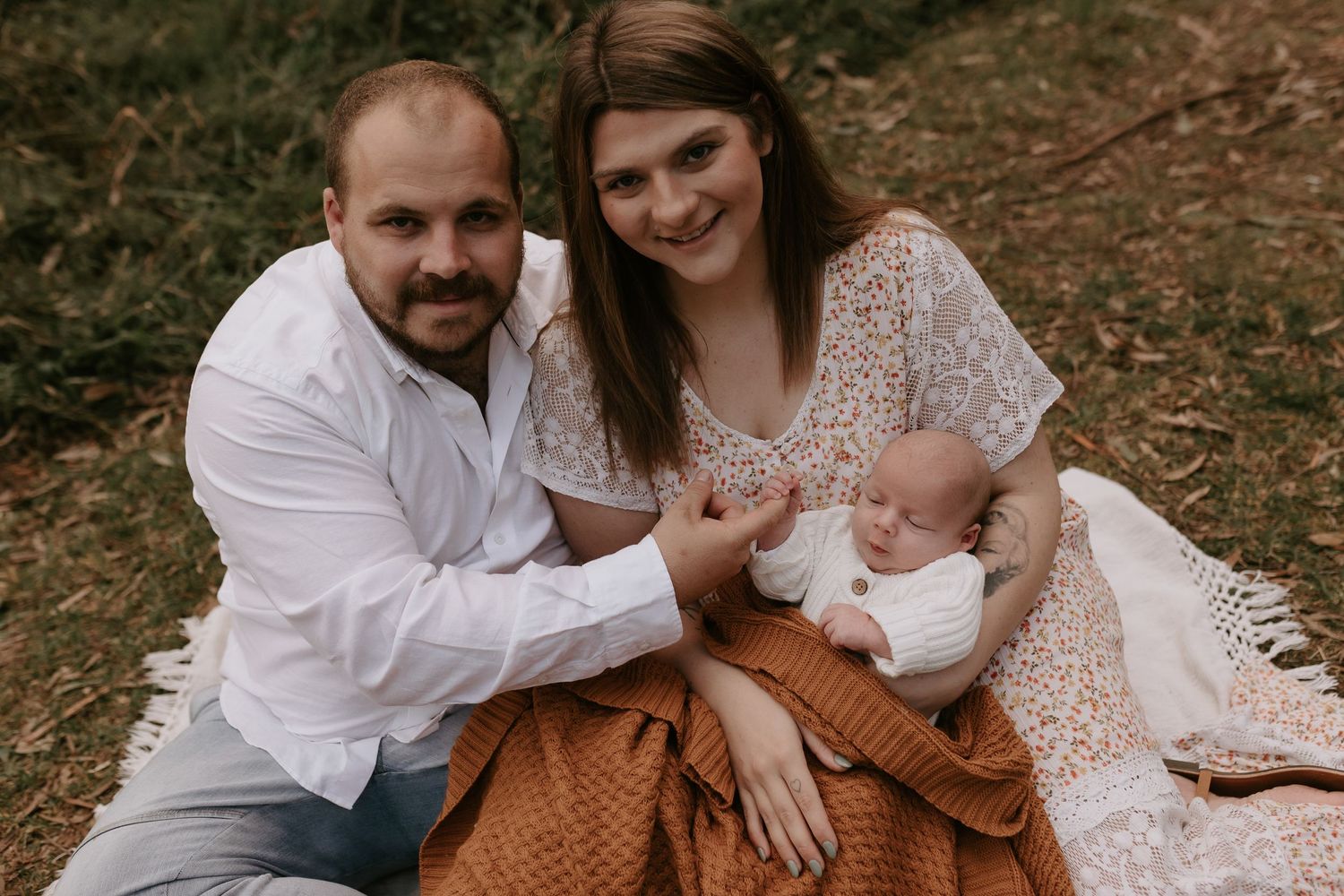 Intimate family moments captured in warm earthy tones during outdoor photo session.