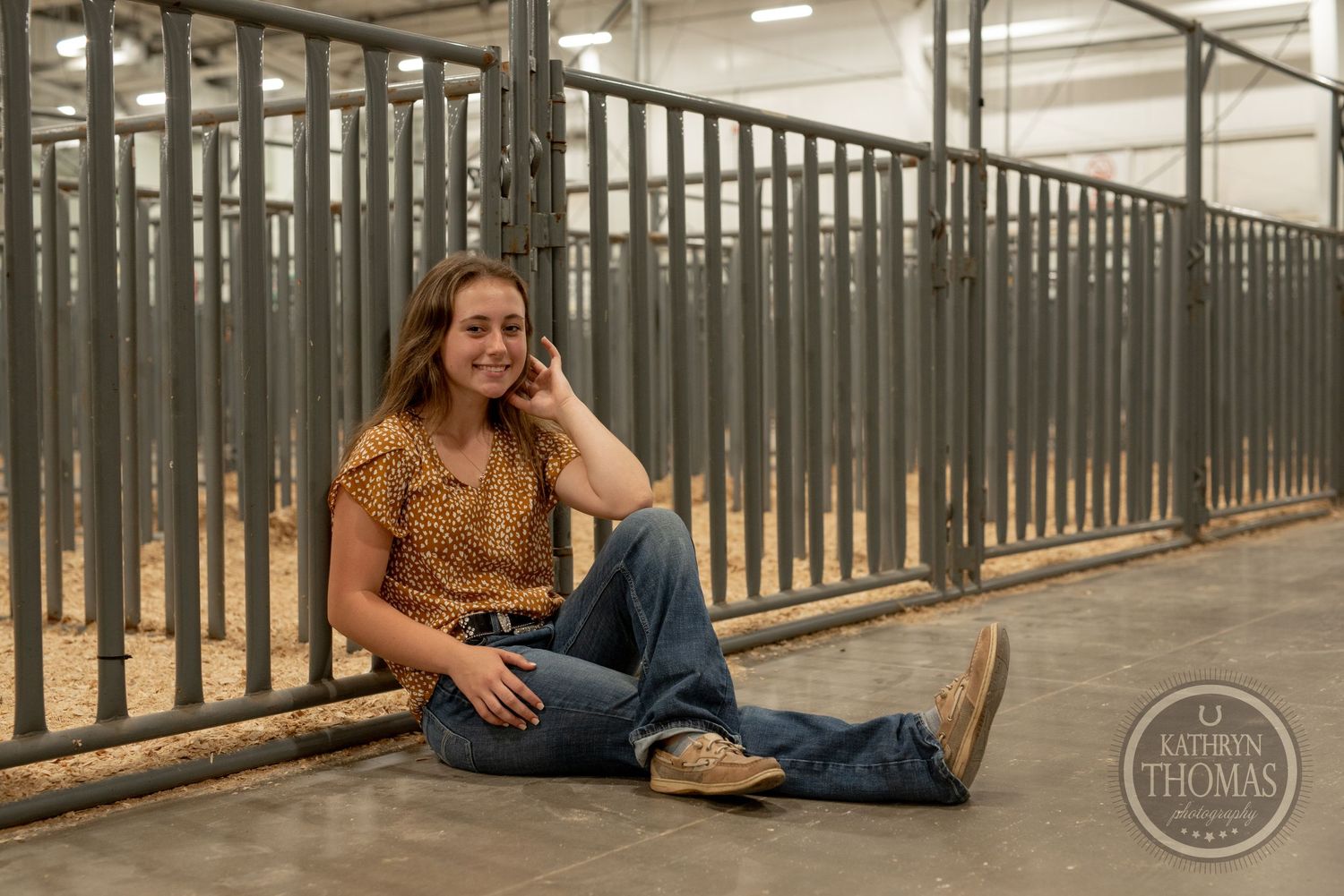 A casual portrait in an industrial hallway featuring a spotted top and jeans against metal railings.