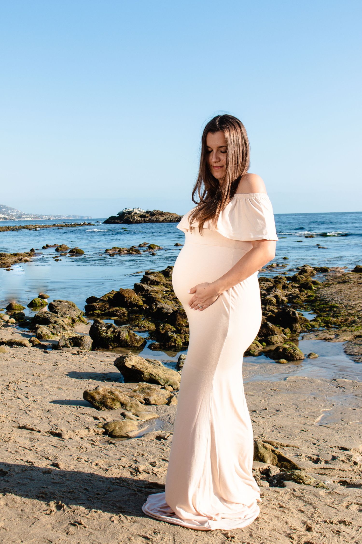 Maternity session with mom's hands on belly in Laguna Beach