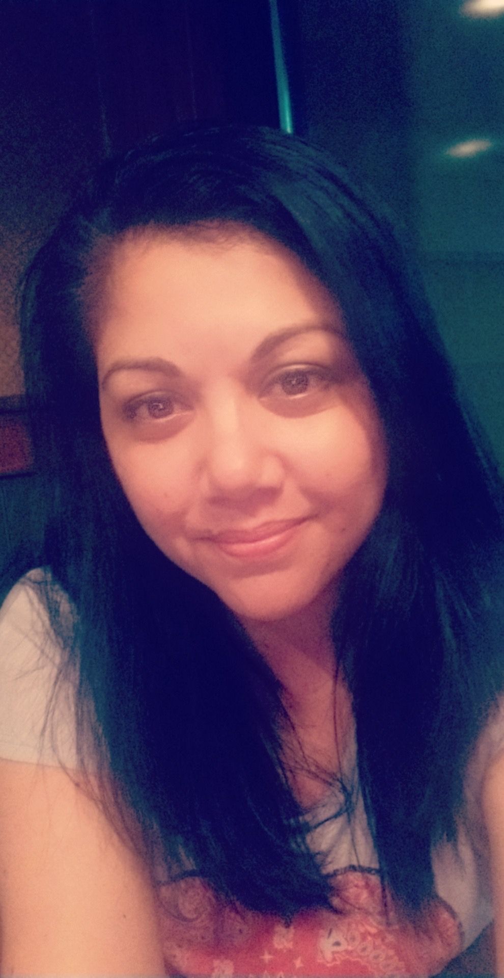 Self portrait style photo in dark lighting with soft smile.