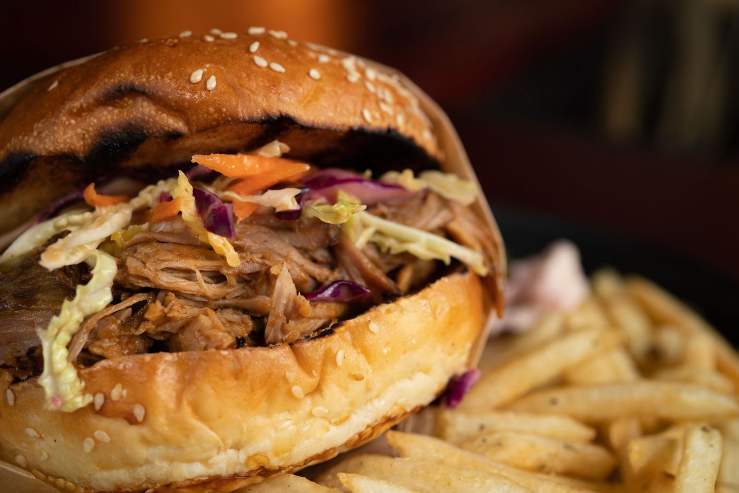Close-up of artisanal burger with brioche bun and fresh toppings.
