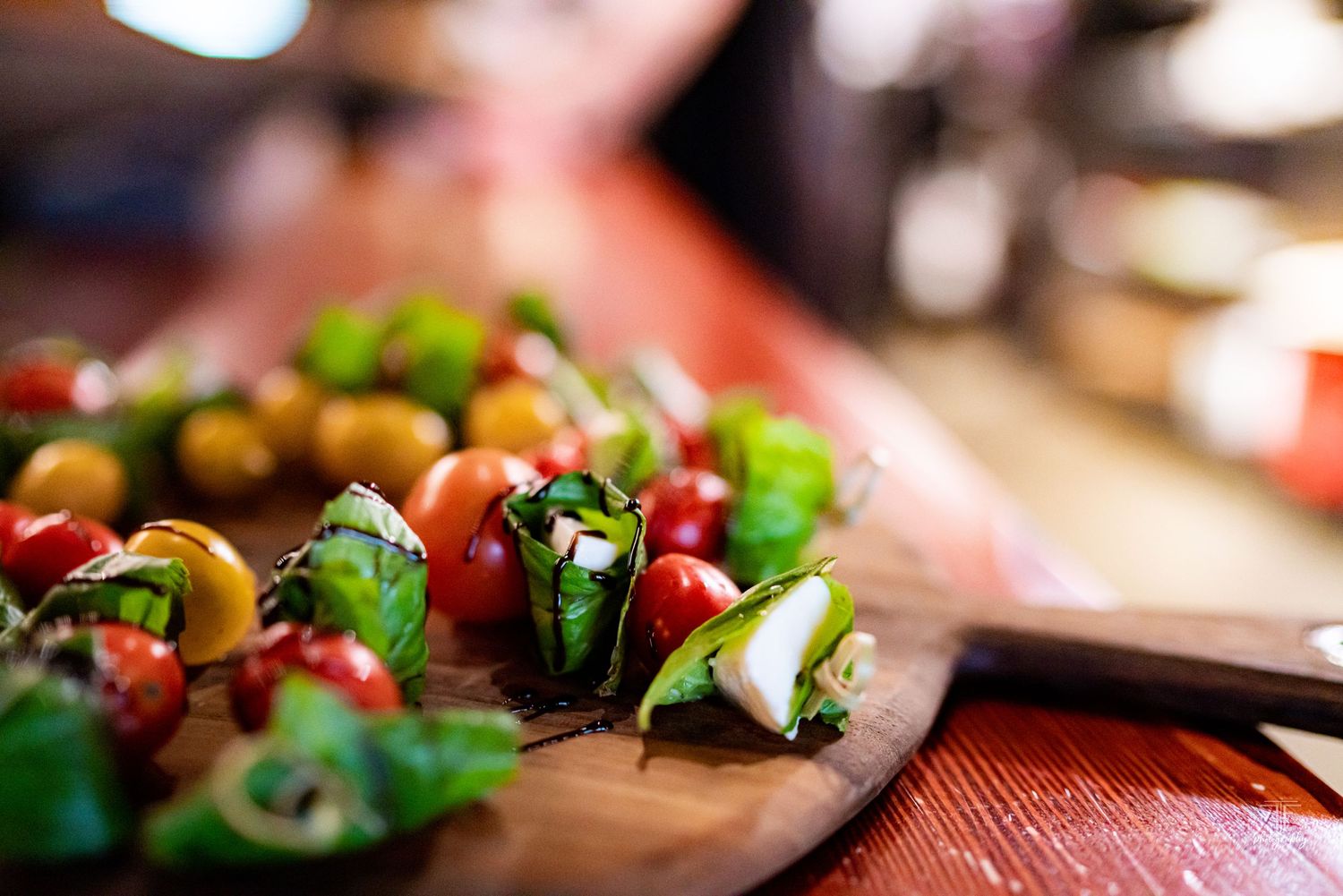 Fresh colorful vegetables and garnishes arranged on wooden cutting board.