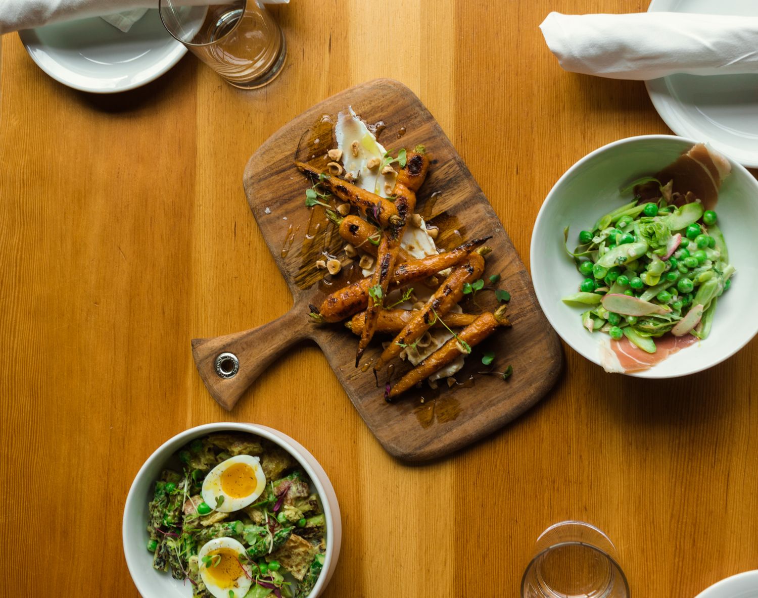 Variety of gourmet dishes and appetizers served on wooden dining table.