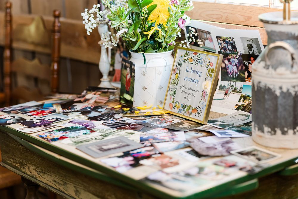 Rustic wedding memory table with vintage photographs and fresh floral arrangements.