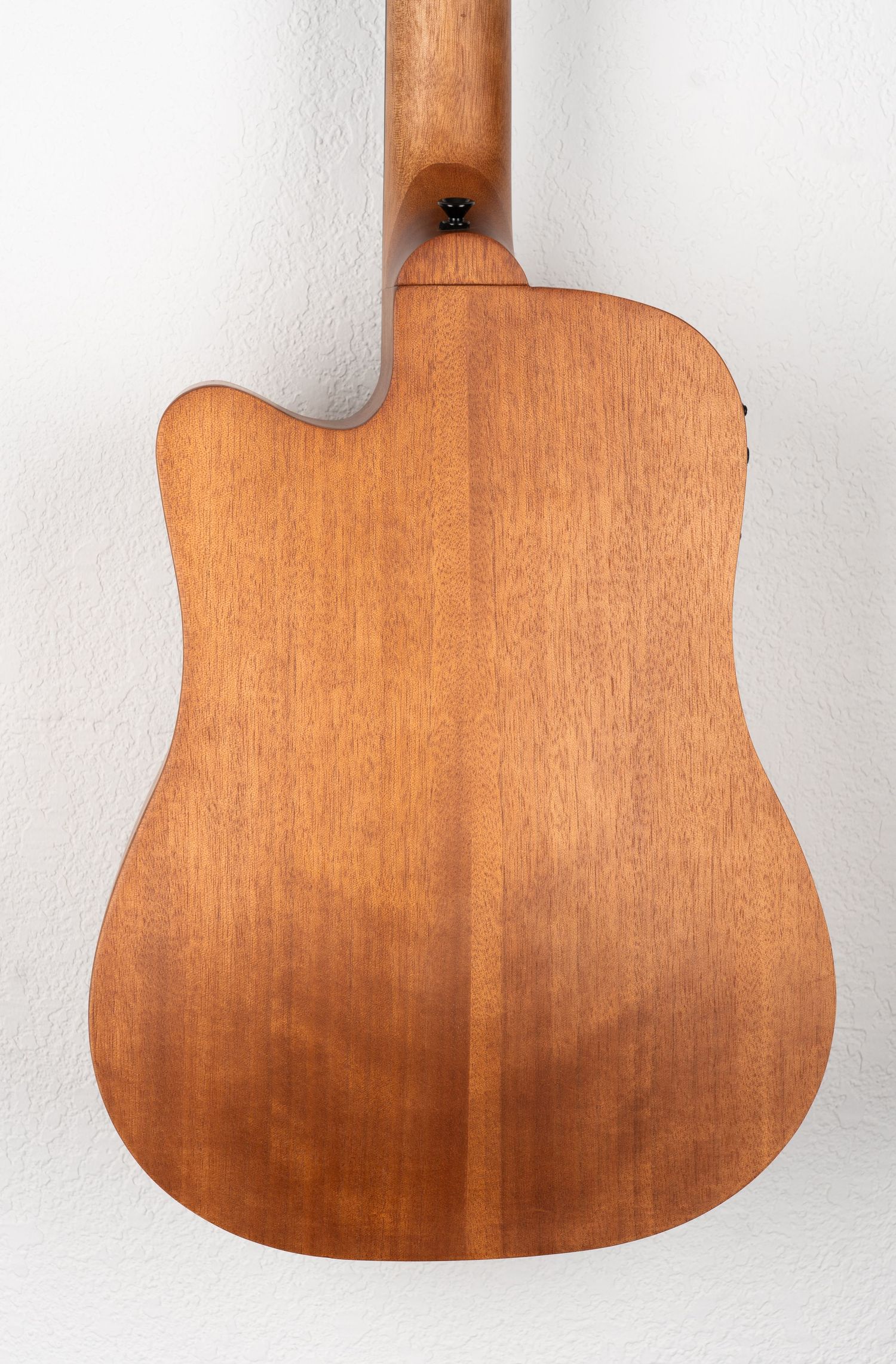 Rear view close-up of acoustic bass guitar body showing mahogany wood grain pattern.