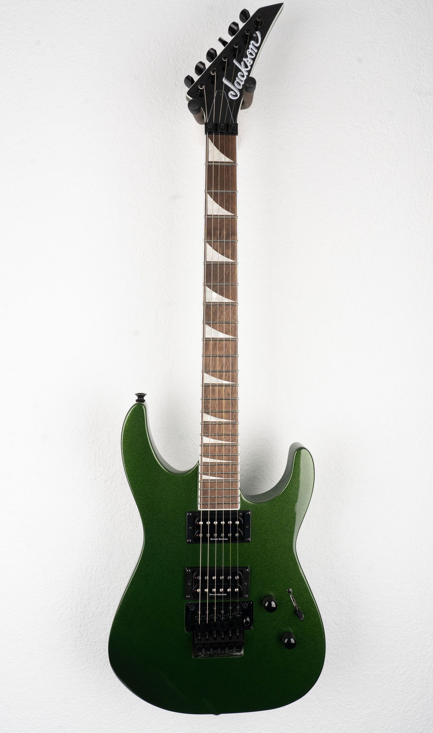 Forest green Jackson electric guitar with dual humbuckers and rosewood fretboard.