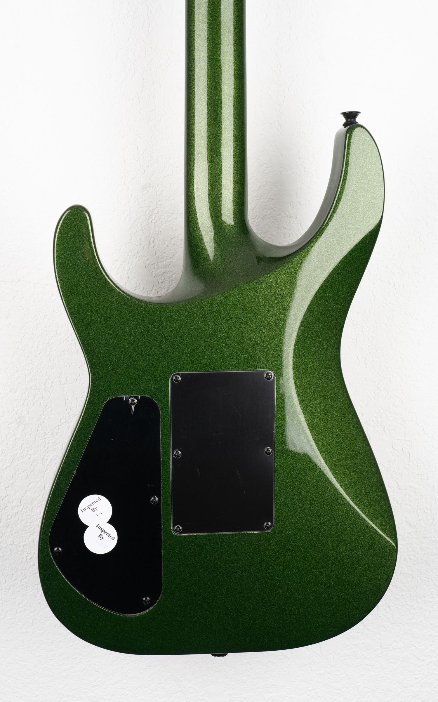 Back view of green electric guitar body showing control cavity covers.