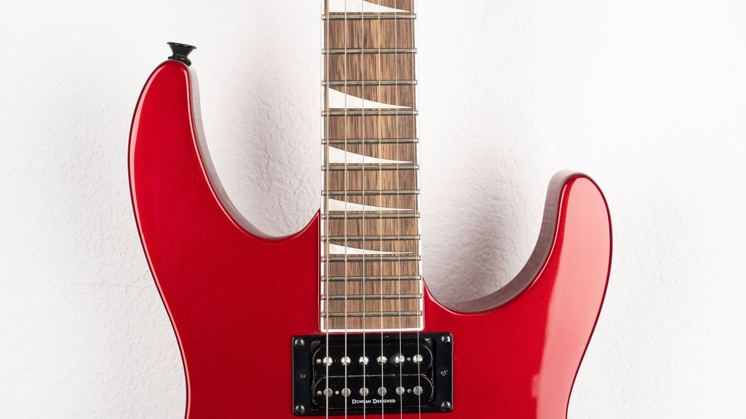 Red electric guitar with maple fretboard and dual humbucker pickups against white background.