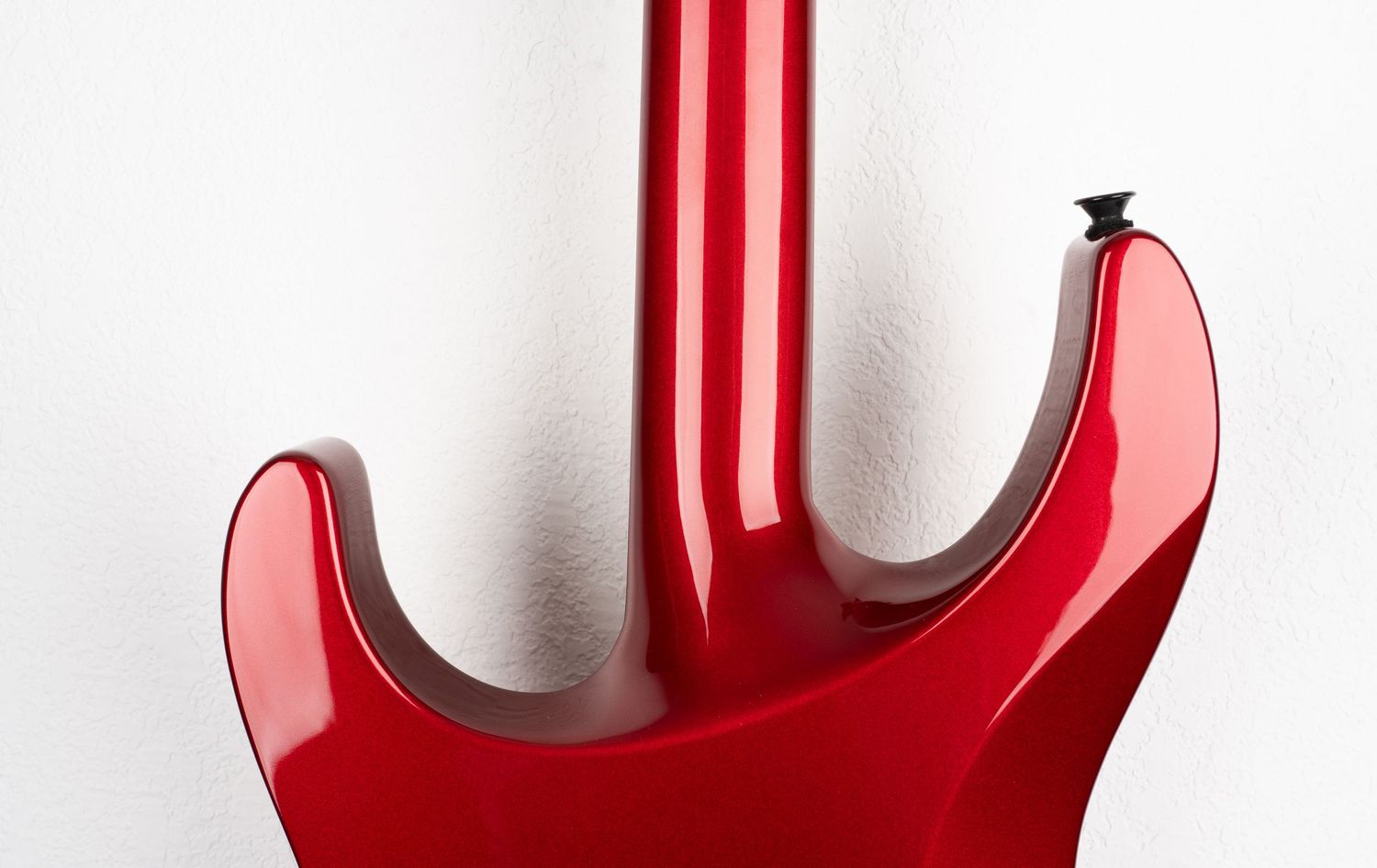 Close-up detail of red electric guitar body contours and finish.