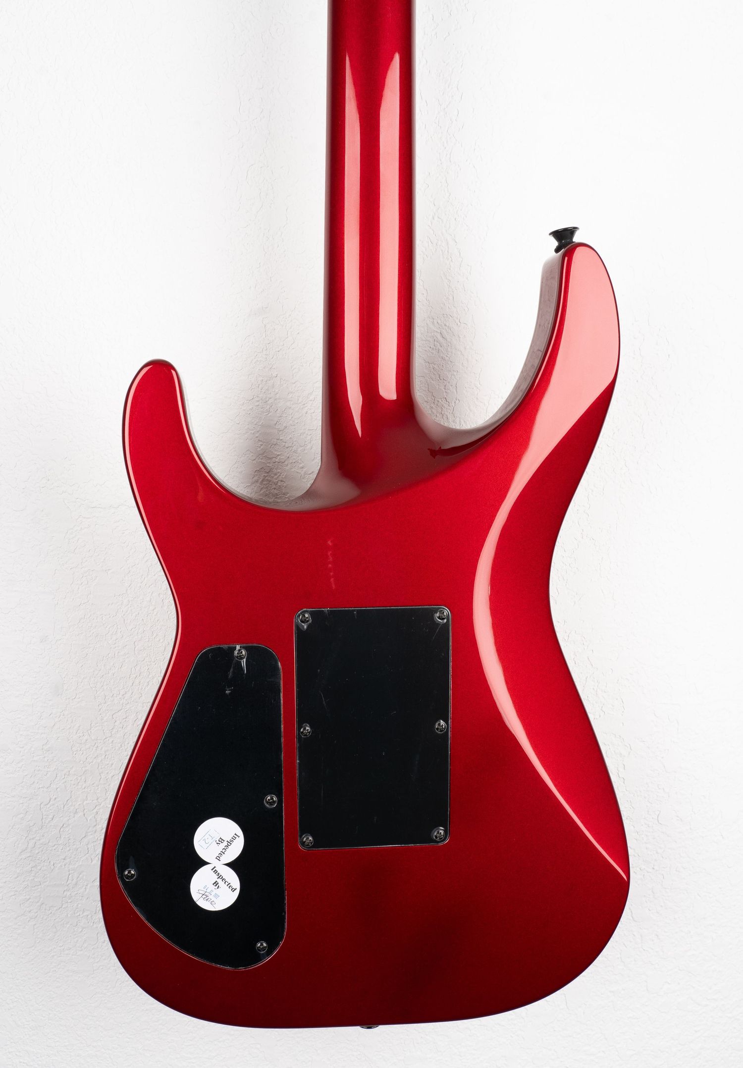 Back view of red electric guitar body showing control cavity covers.