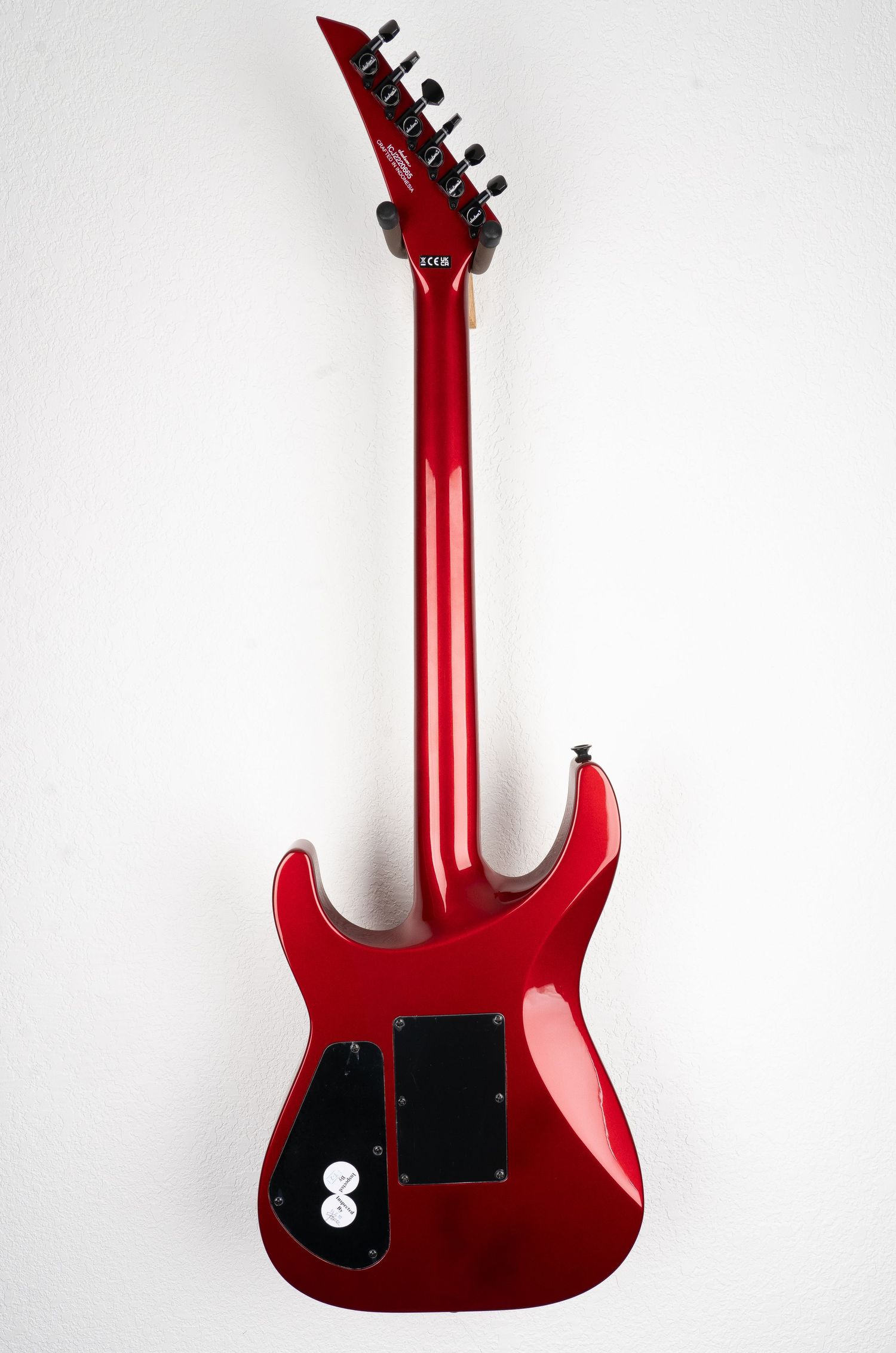 Full back view of red Jackson electric guitar with black hardware.