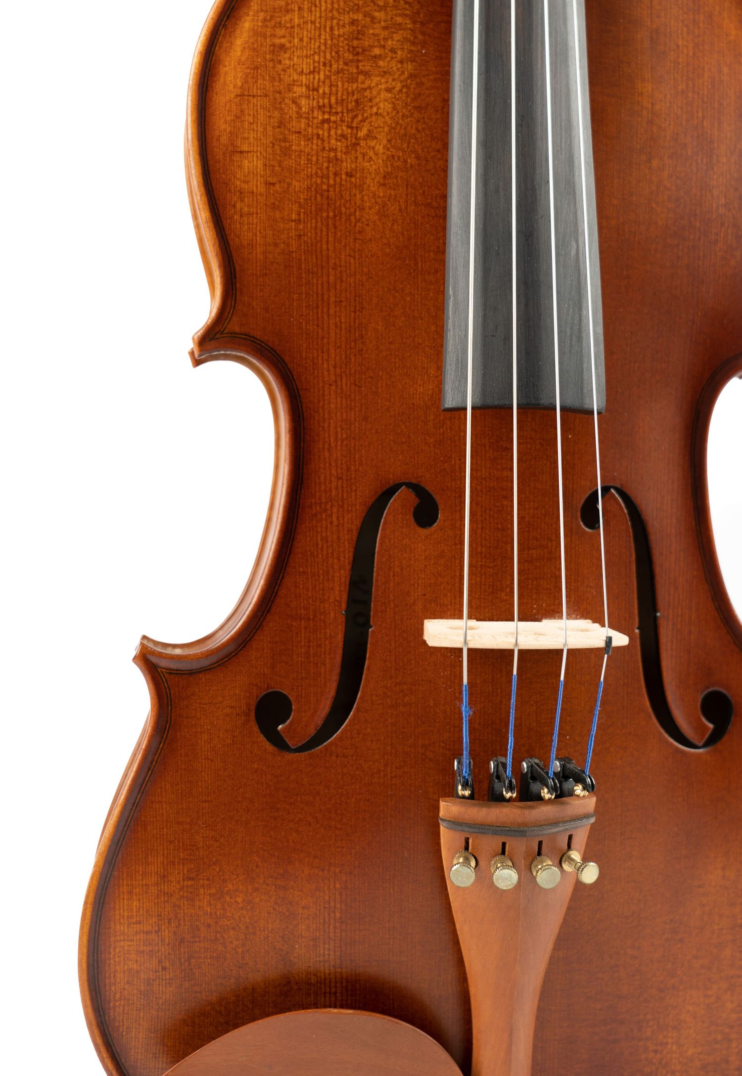 Close-up of violin body showing detailed bridge, strings and f-hole on brown wooden surface.
