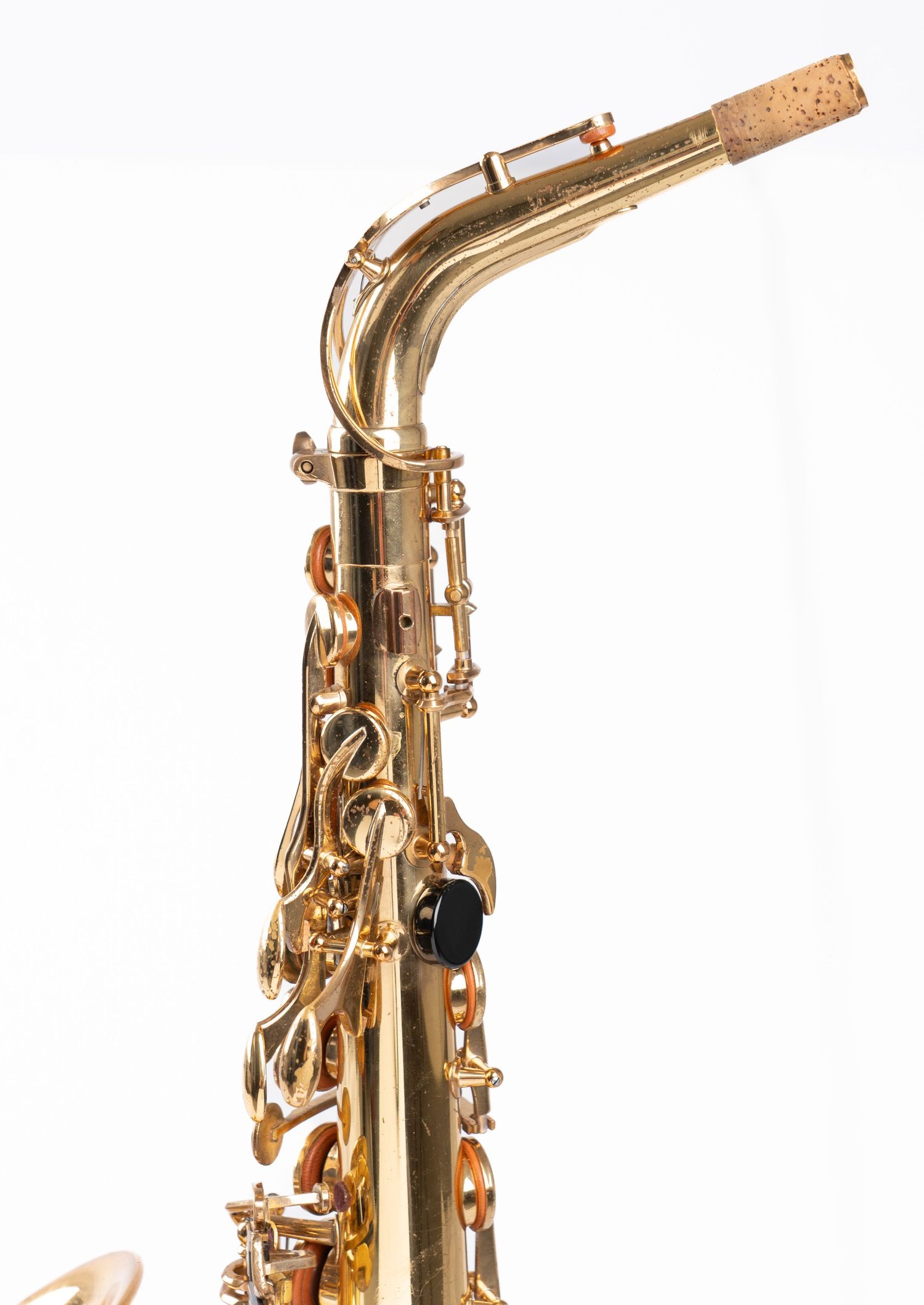 Gold alto saxophone upper section showing mouthpiece and intricate key details.