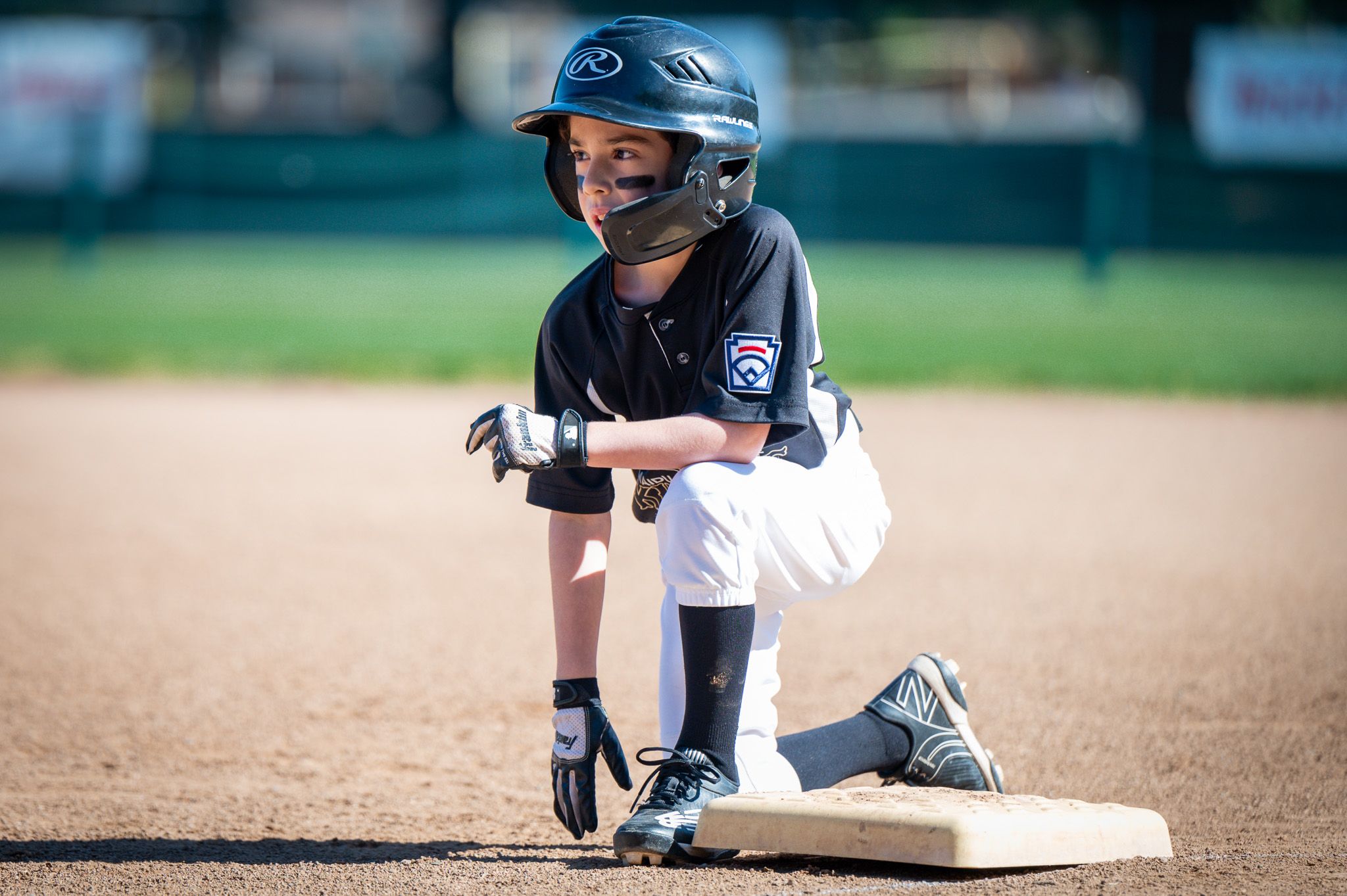 Baseball player kneeling on base
