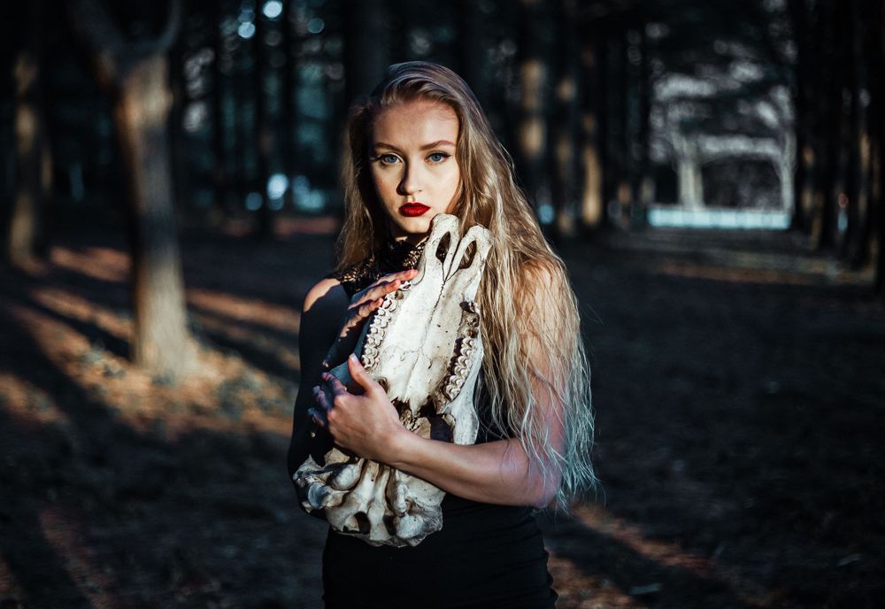model poses, holding skull