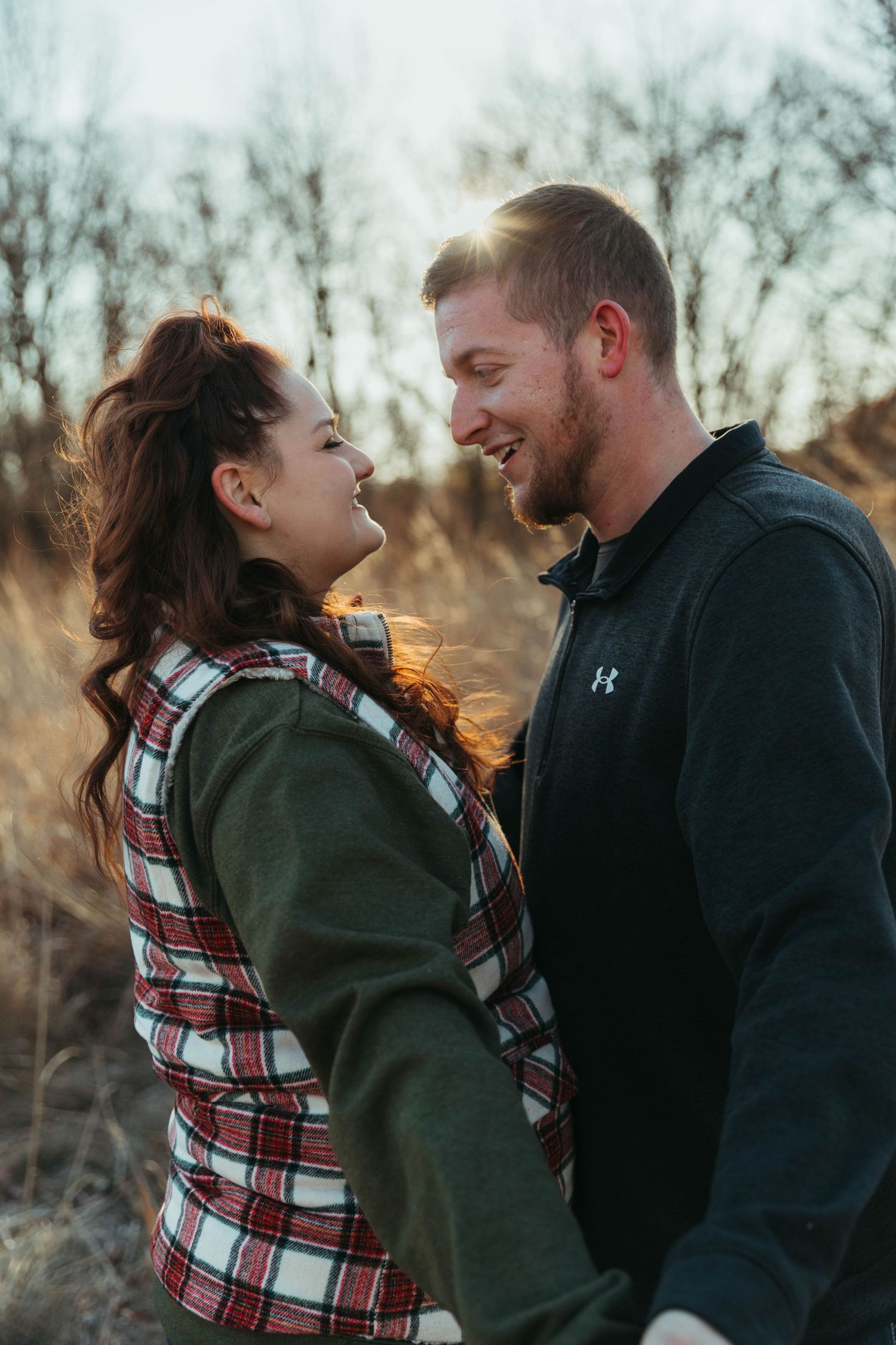 Couple sharing playful moments outdoors wearing casual winter clothing.