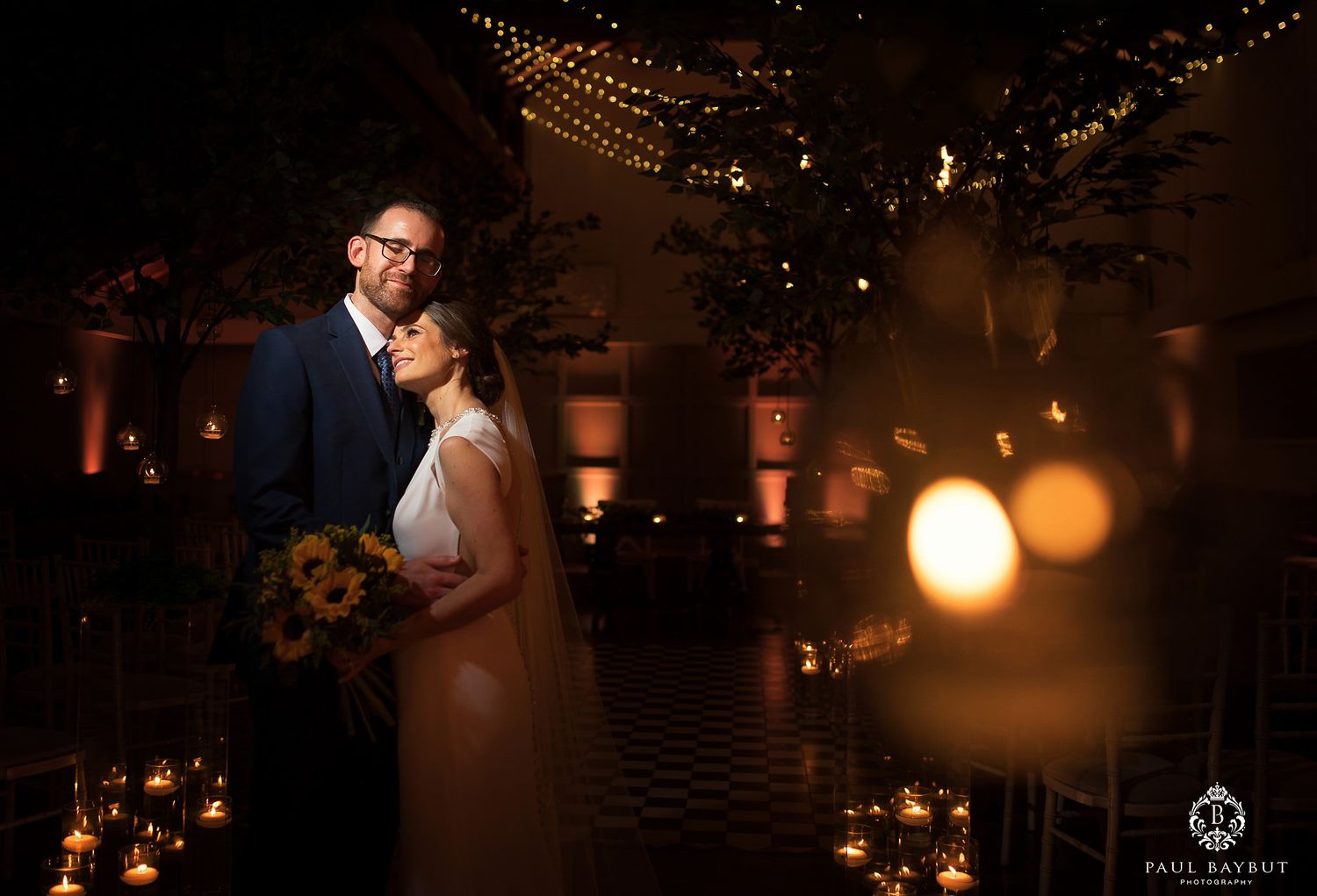 Bride and groom snuggle together by candlelight in the Larkspur lodge wedding ceremony room