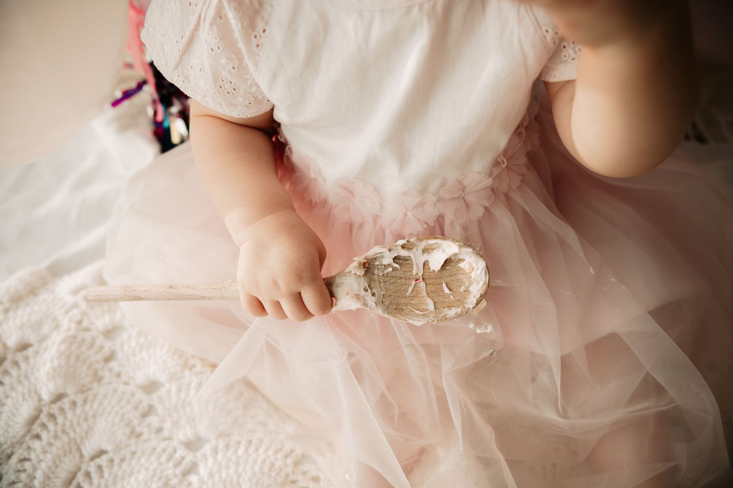 close up of baby hands holding wooden spoon