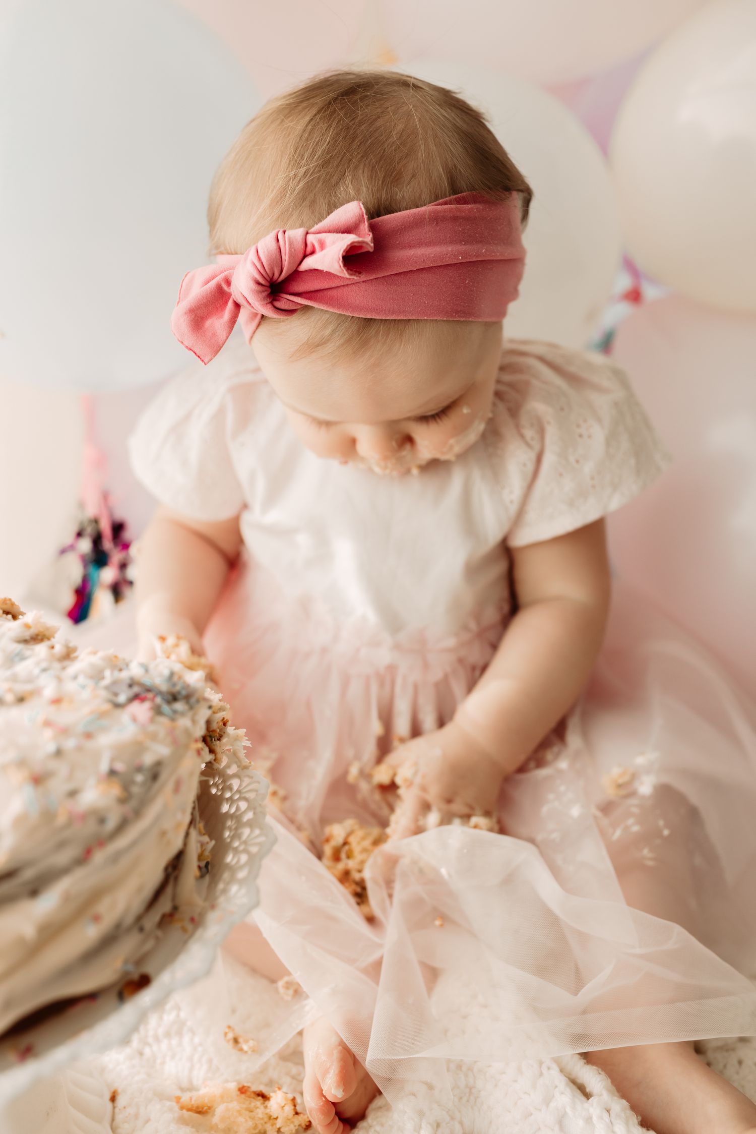baby girl covered in birthday cake