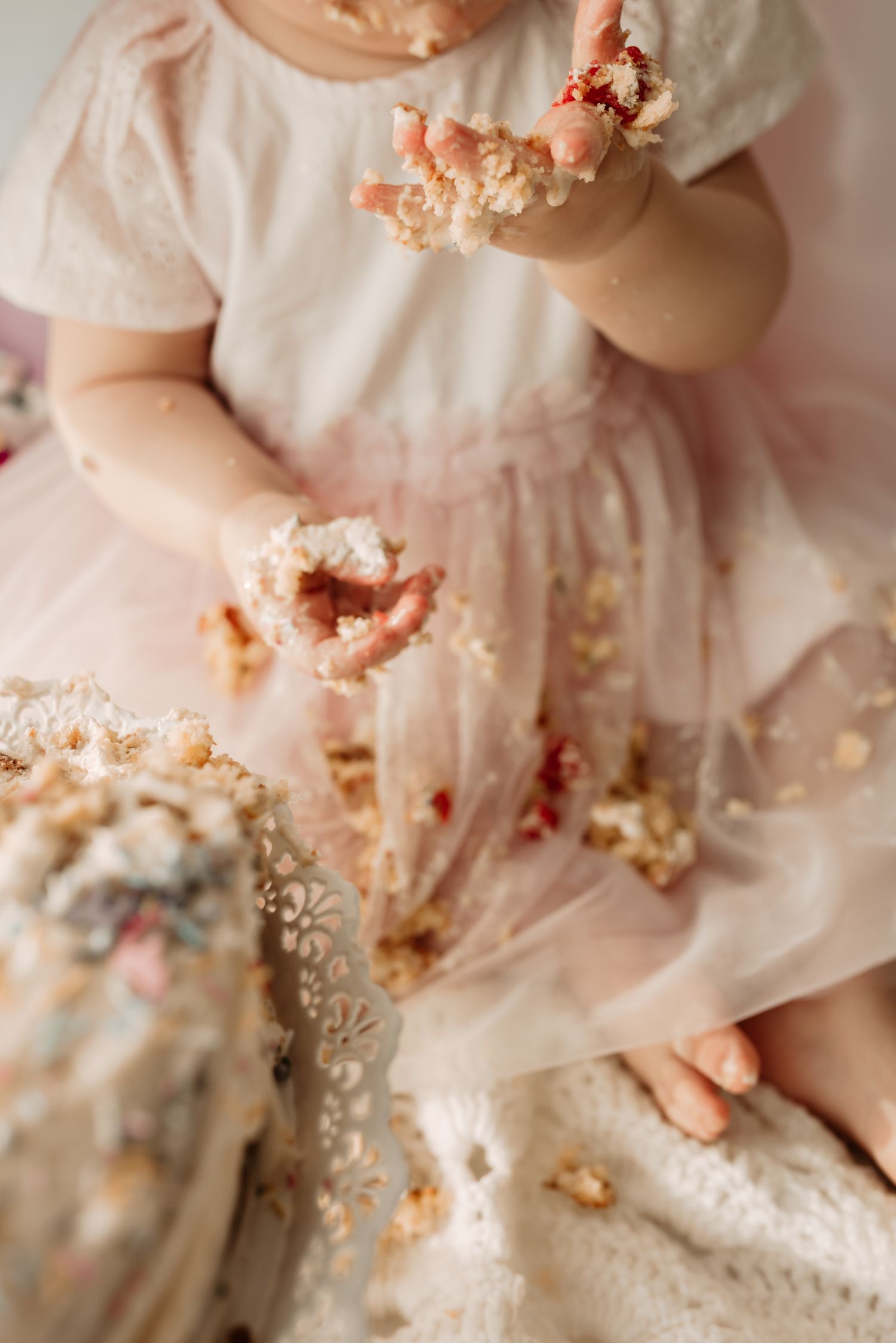 close up of baby girls hands covered in icing