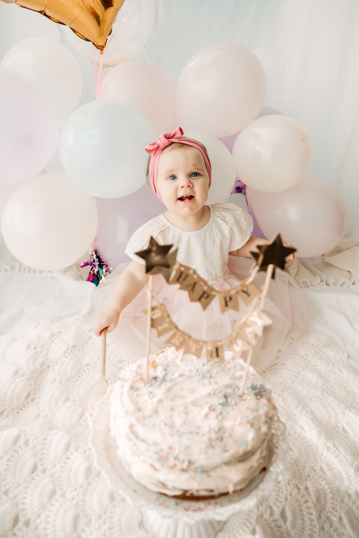 smiling baby girl with first  birthday cake