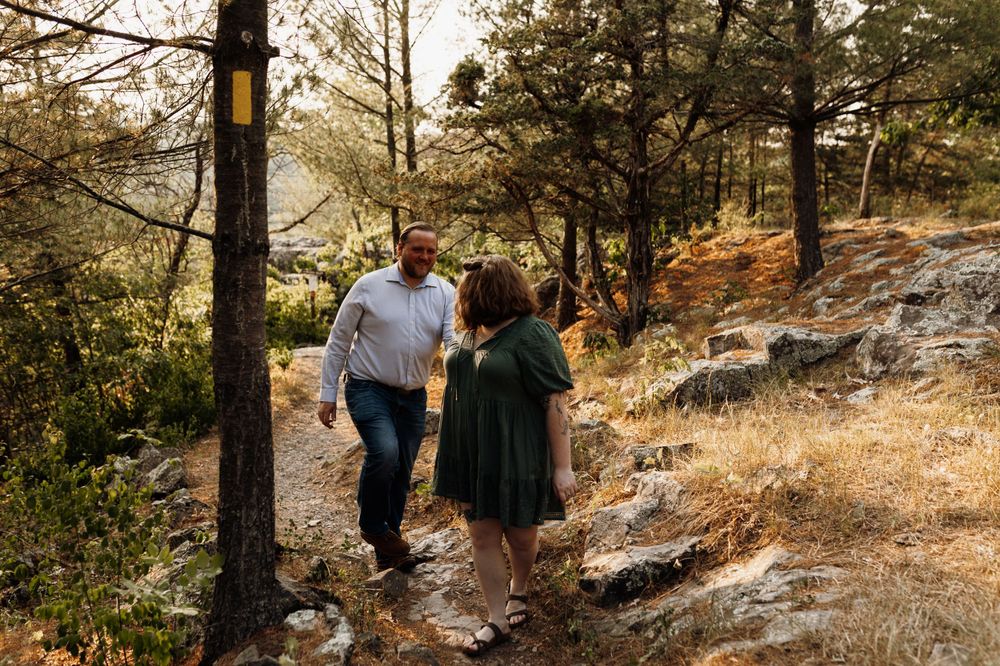 Couple walking together on a rocky mountain trail during autumn.