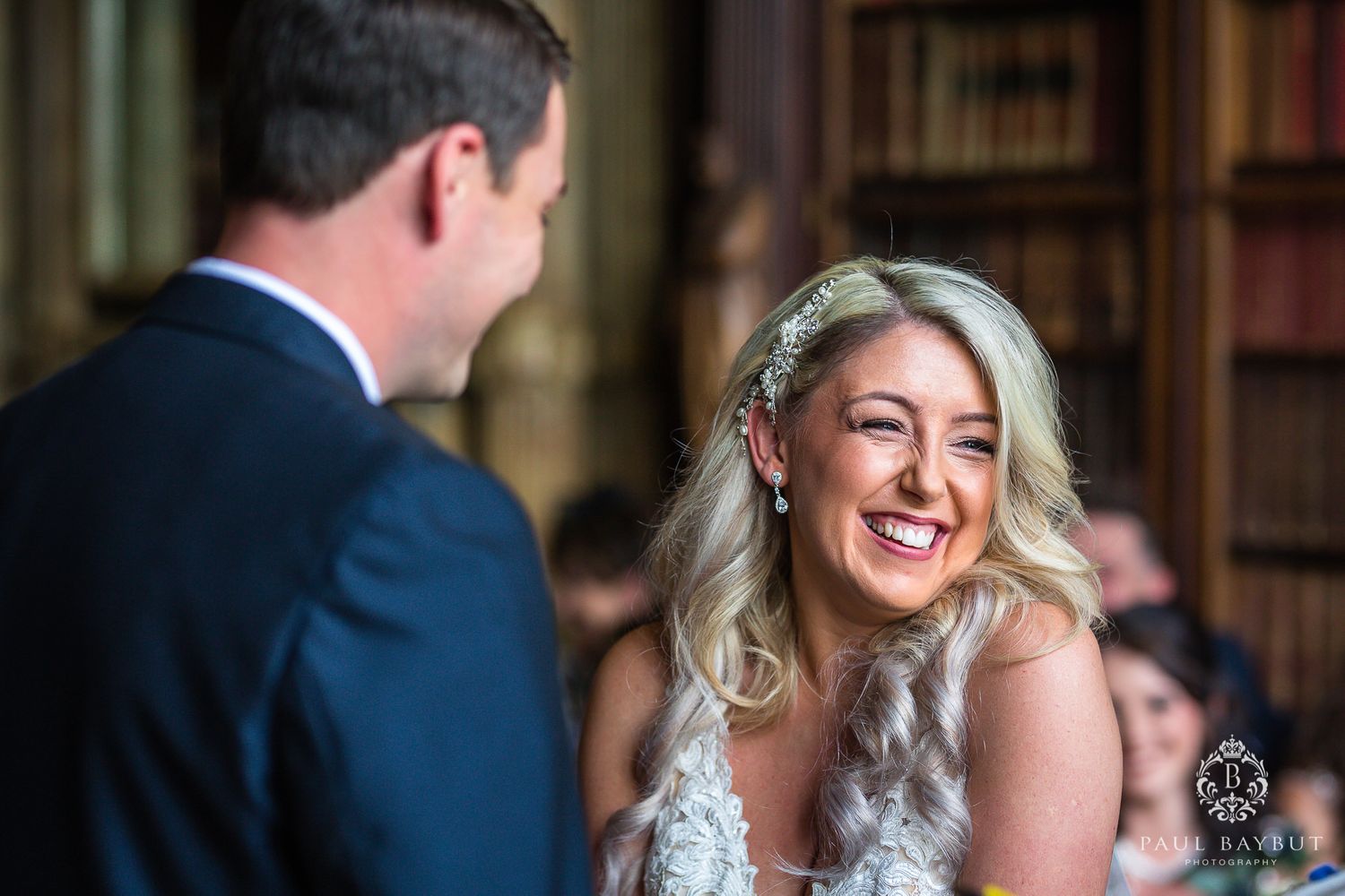 Joyful moment captured during wedding ceremony in vintage library setting.