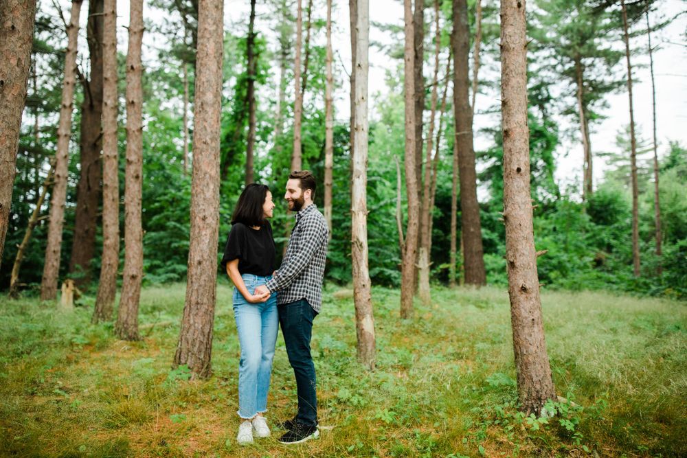 A couple embraces in a misty evergreen forest.
