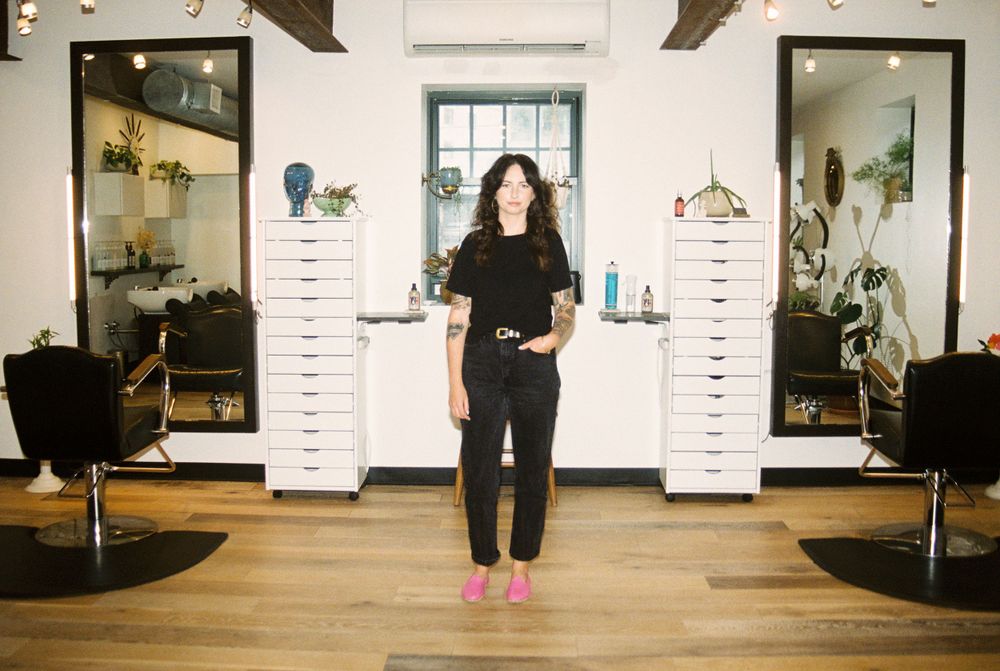 Hair salon interior featuring white storage units and exposed wooden beams.
