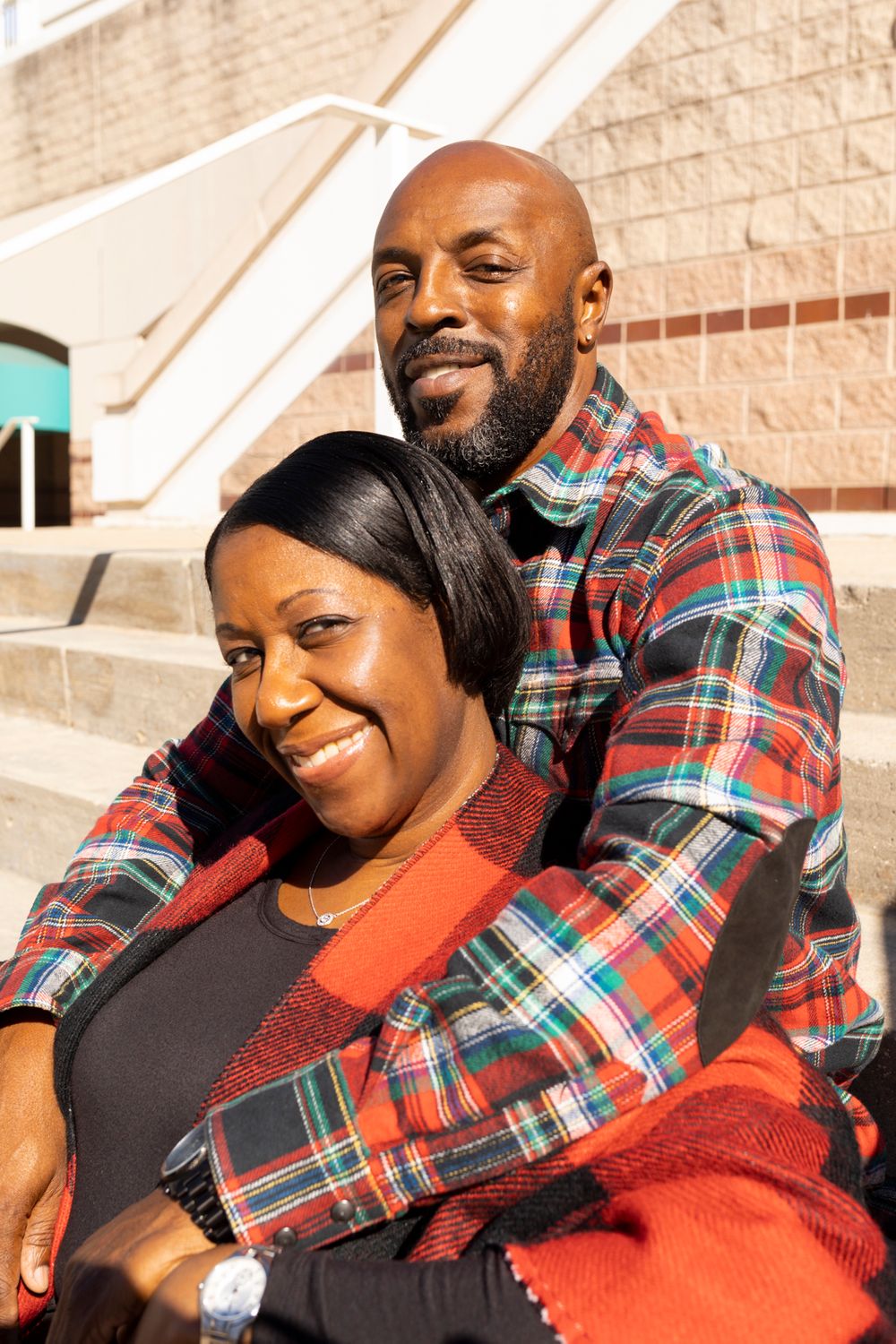 A couple sitting on stairs with their arms wrapped around each other.