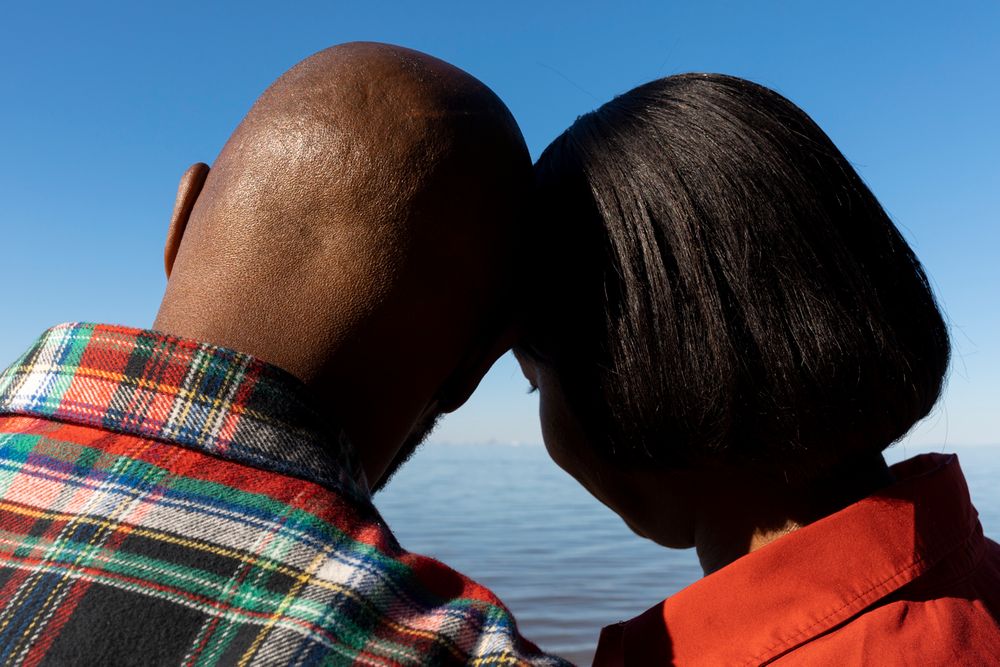 A couple leaning their heads together.
