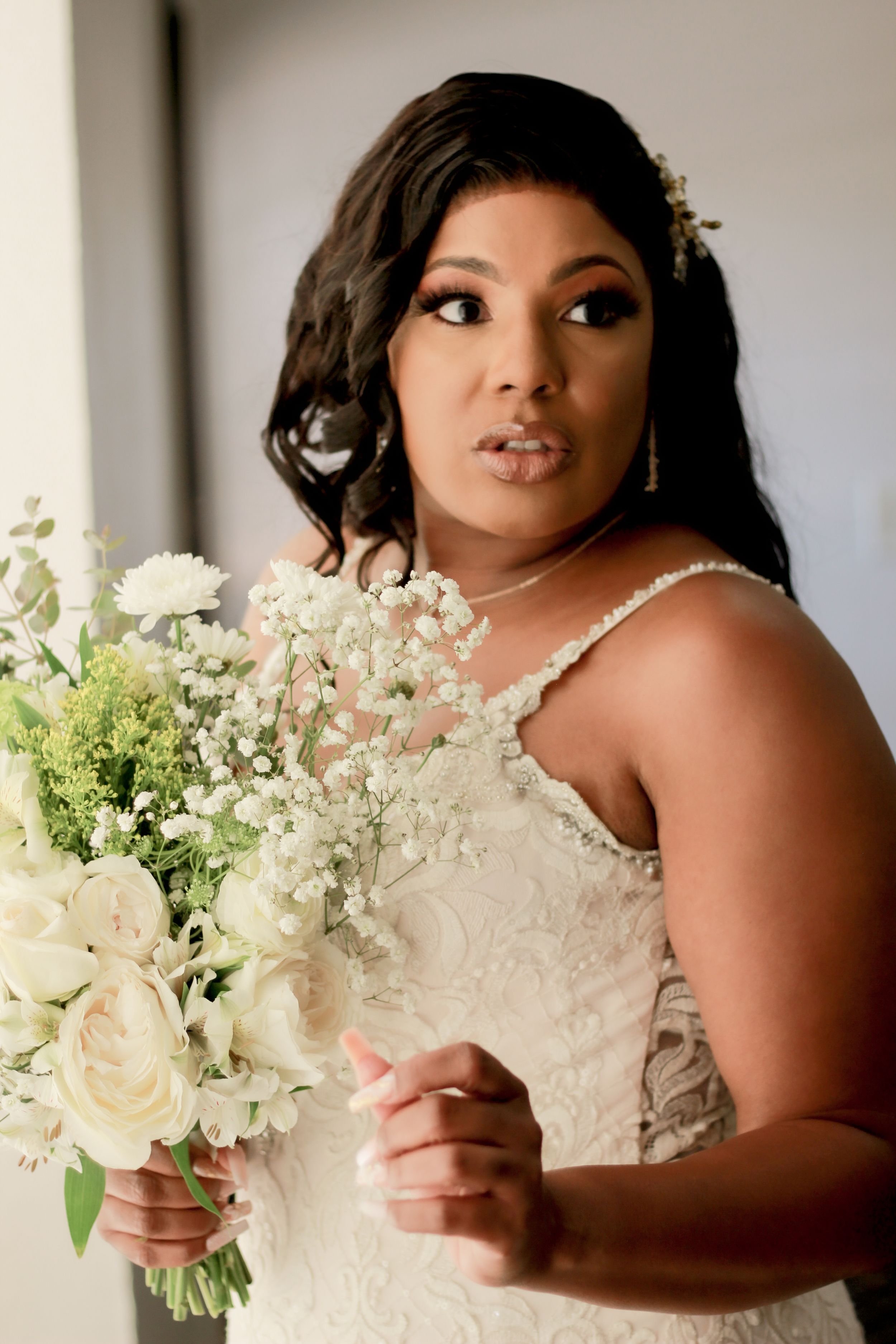 Elegant bridal portrait with white bouquet and ornate hair accessory.