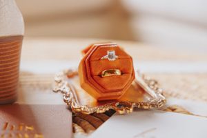 Wedding accessories featuring gold wax seals and decorative trays in warm lighting.