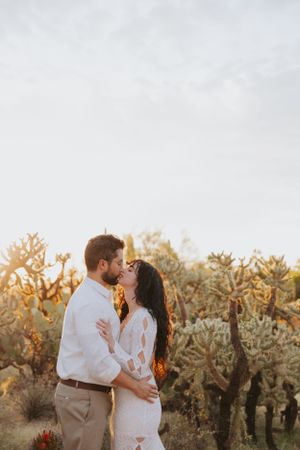 A romantic desert wedding photoshoot with towering saguaros and golden sunlight.