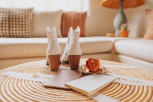 Wedding details styled on circular woven placemat in warm natural light.