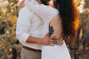 An intimate embrace captured during a desert wedding photoshoot at golden hour.