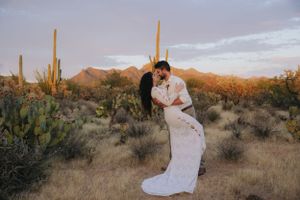 Desert engagement session with mountains and cacti silhouetted against the evening sky.