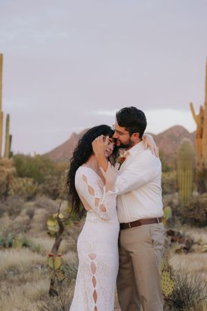 Intimate desert photoshoot featuring a couple in formal attire among native Arizona flora.